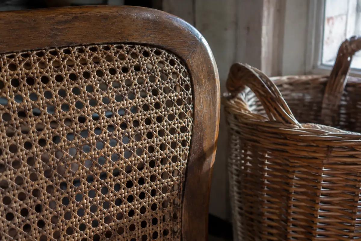 Dossier en cannage d'une chaise ancienne et panier en osier, fibres vues de près